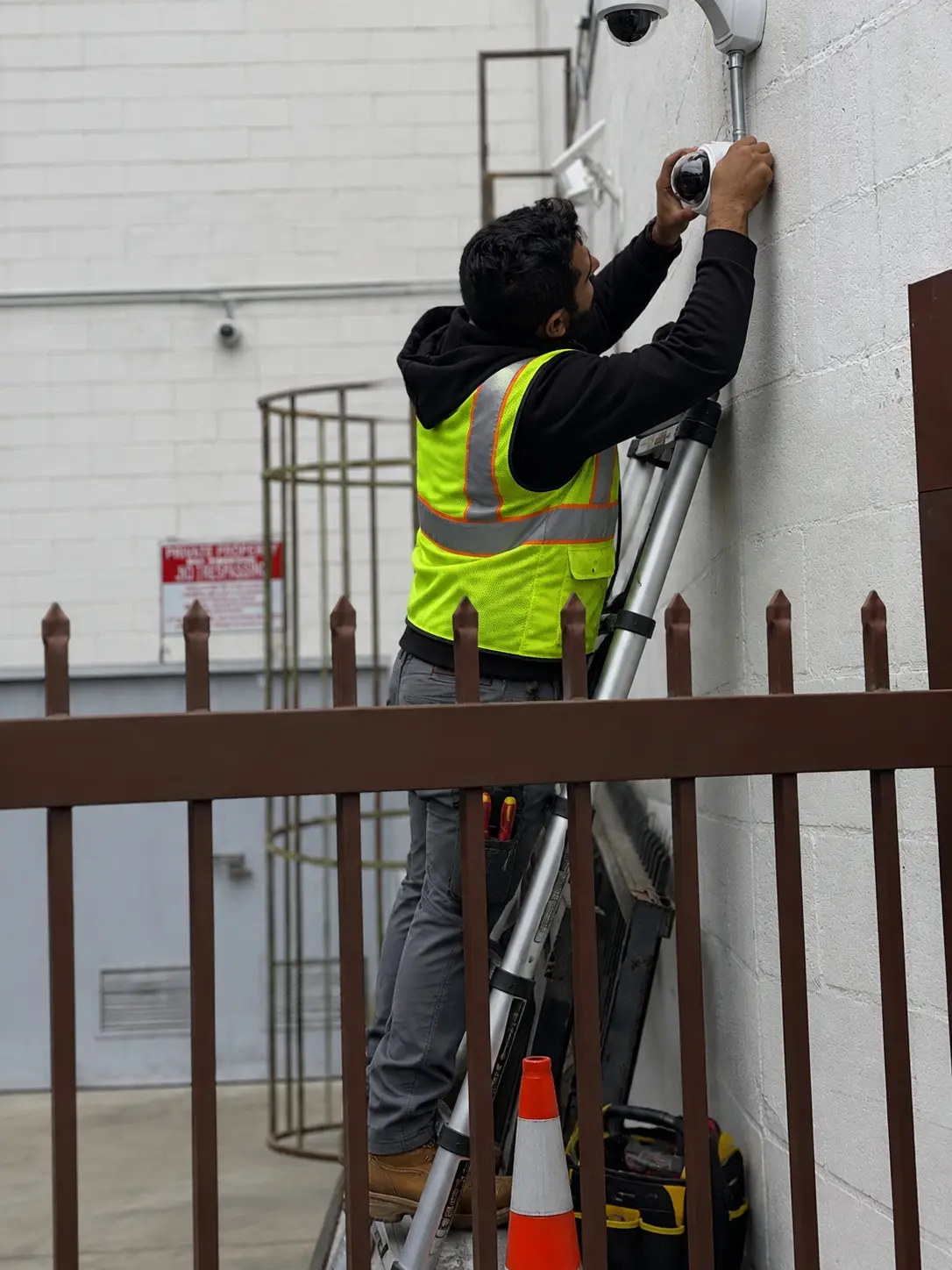 Three Factor Security technicians fully visible while servicing exterior commercial cameras — Three Factor Security fieldwork in Mission Viejo